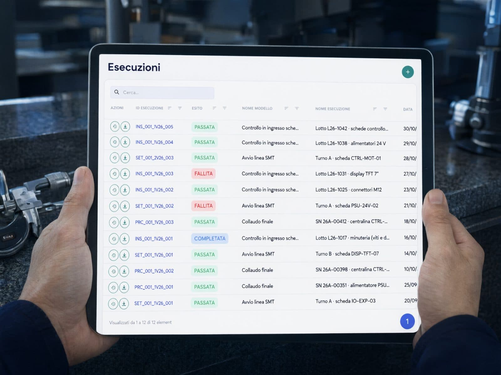An operator’s hands holding a tablet with the Virtus QMS checklists, in the metrology lab